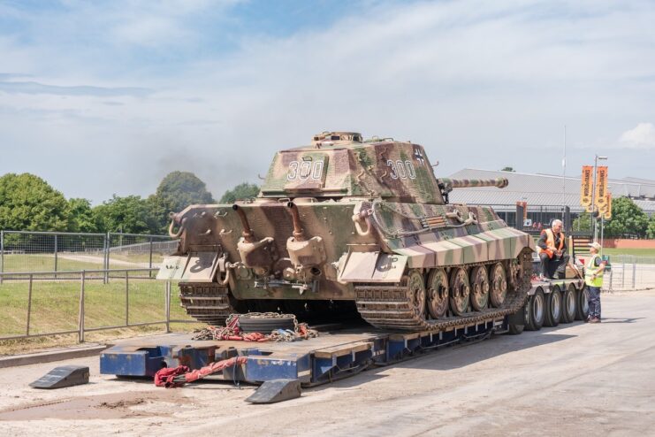 Men standing around a truck flatbed carrying a King Tiger