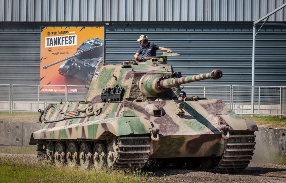 Man standing in a King Tiger that's parked outside of a building