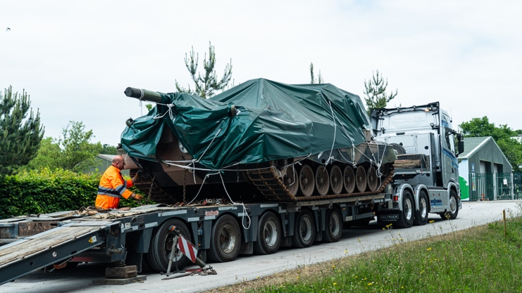 Tarp-covered Leopard AS1 on the back of a truck bed