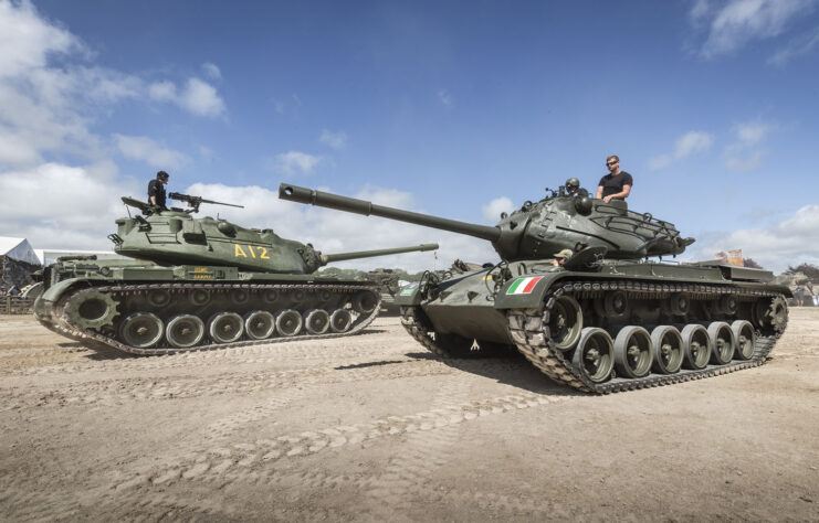 Two tanks driving past each over on a dirt path