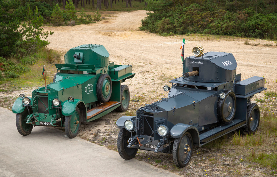 Two Rolls-Royce armoured cars parked next to each other along the side of a road