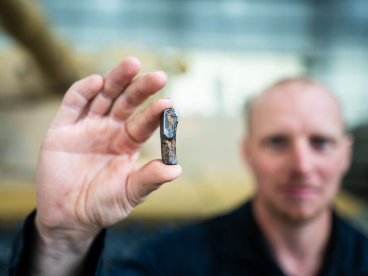 Man holding up a piece of shrapnel