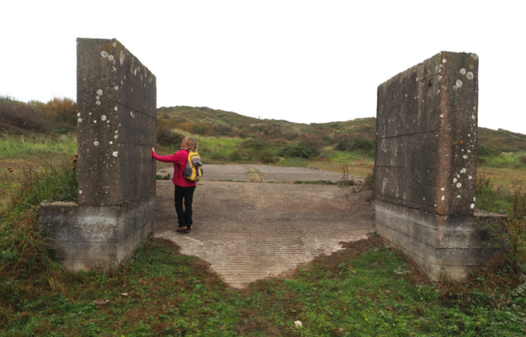 Woman standing between two slabs of stone outside