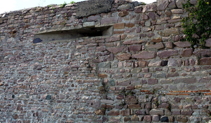 View of a machine gun slit cut into a brick wall