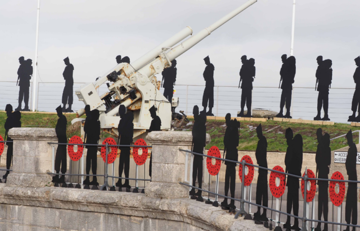 Standing with Giants display set up near a naval gun from World War II