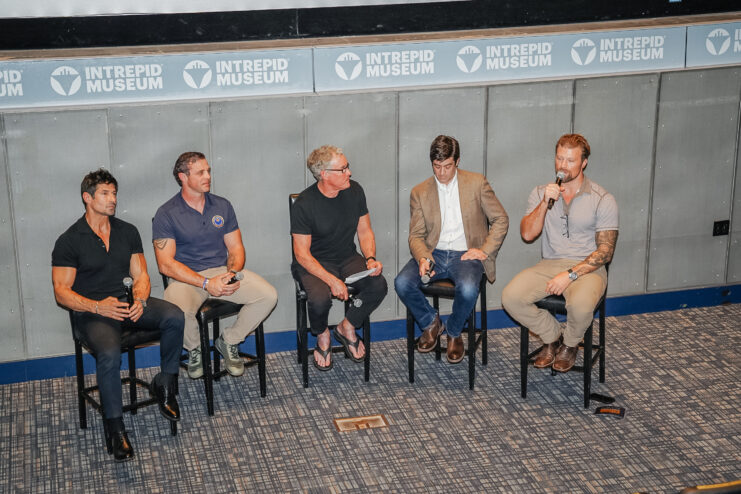 Rudy Reyes and four other men sitting on a stage
