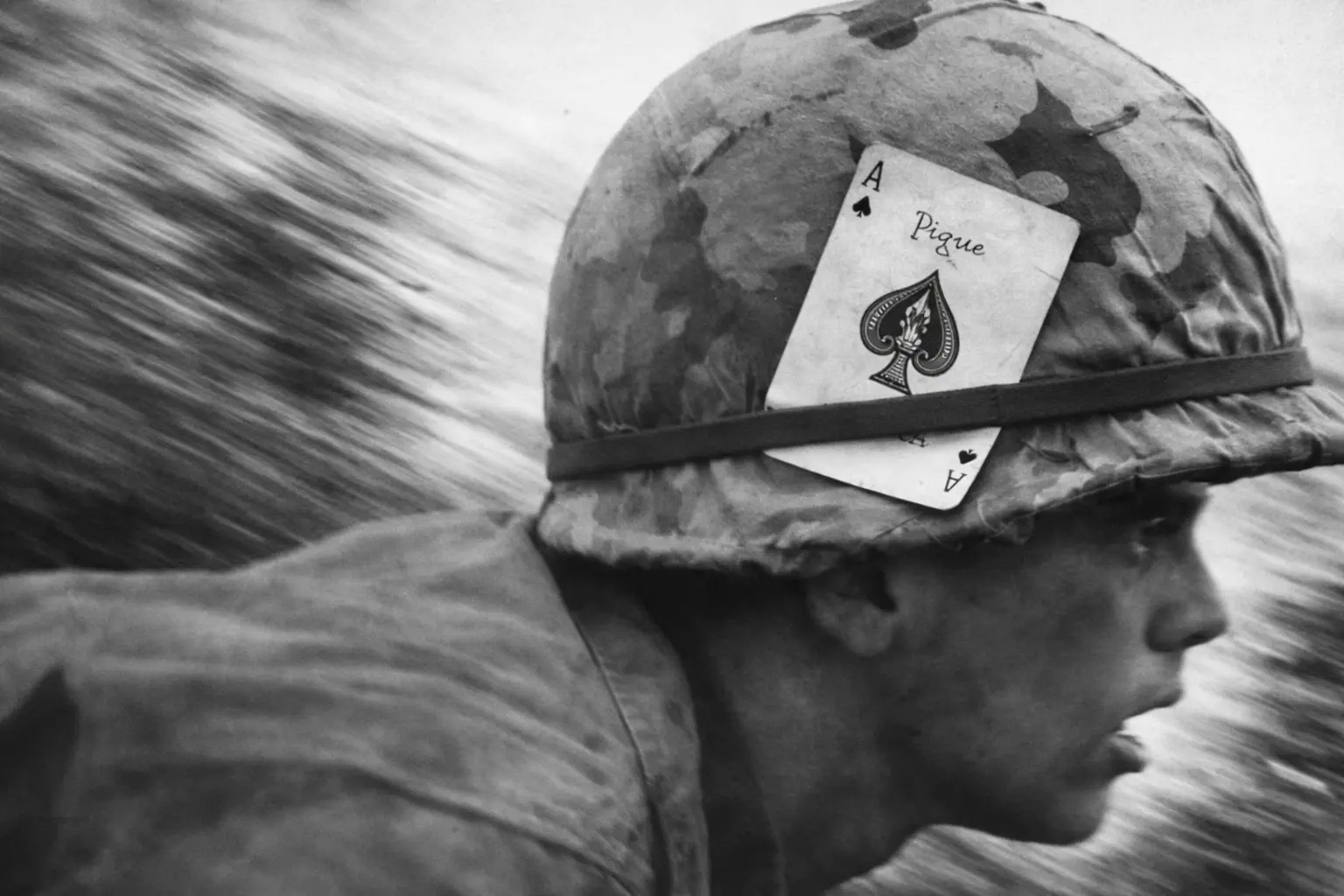 An American soldier in Vietnam with an Ace of Spades card attached to his M1 helmet.