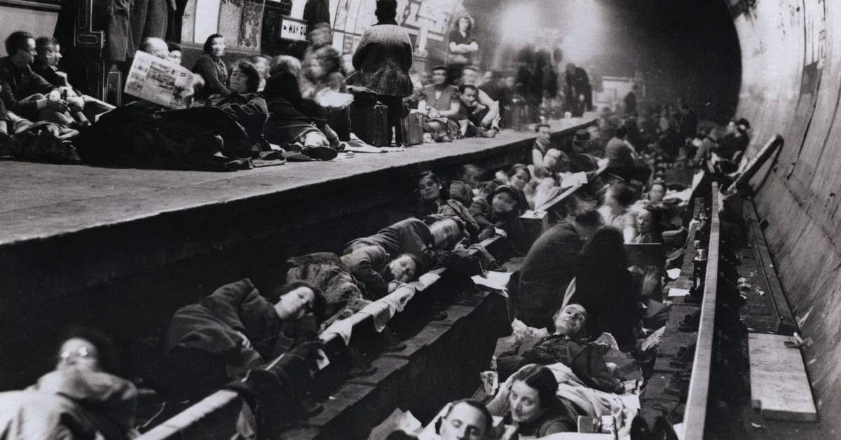London, England, 12 Oct 1940: Weary London are shown catching up on sleep in the comparative safety of a tube station, taken out of service and converted into an air raid shelter. Trucks as well as the platform are used.
