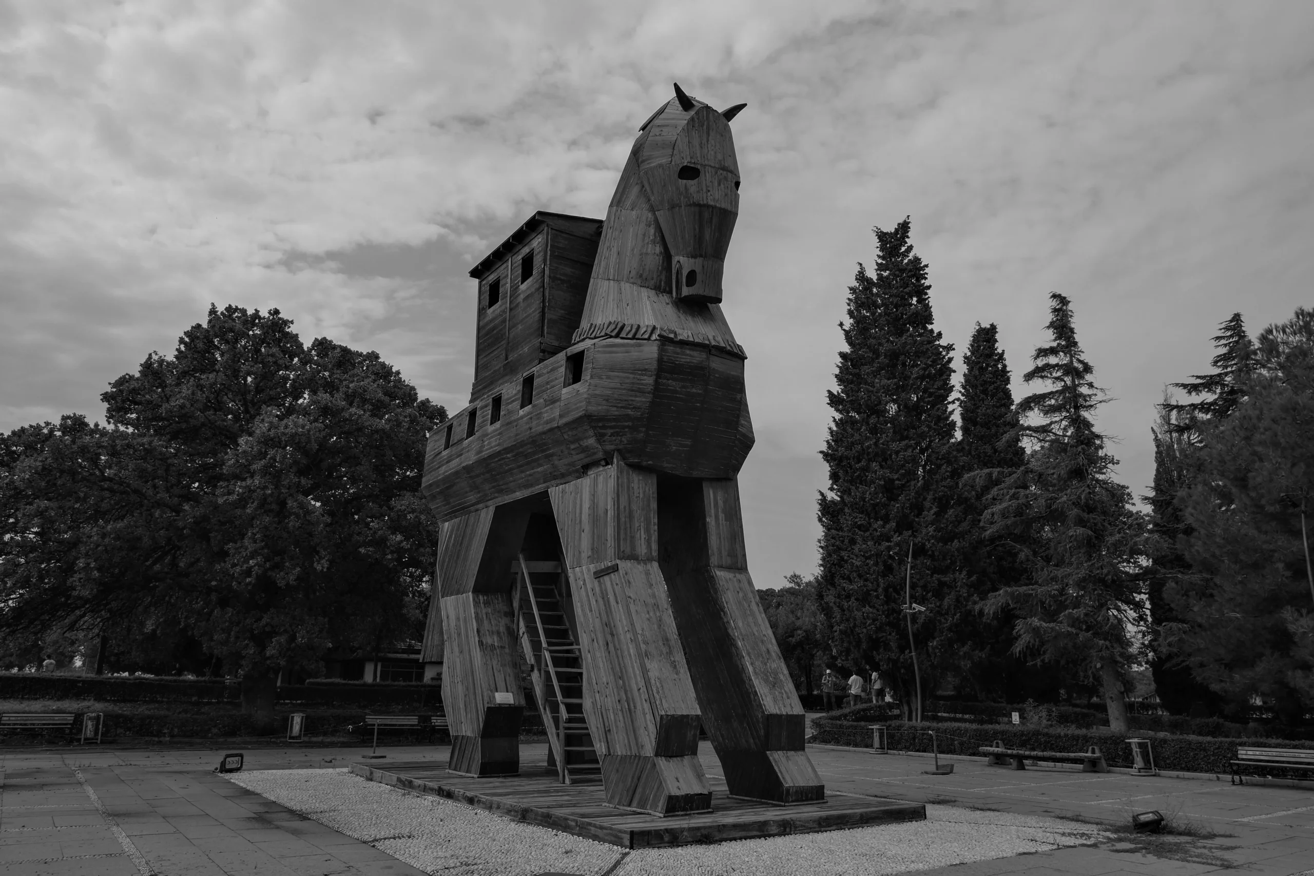 A black and white image of a Trojan Horse replica being displayed in the open.
