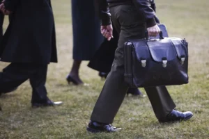 A military officer carries "The Football" onto Marine One as President Barack Obama departs the White House in Washington. The Nuclear Football is a black briefcase meant to be used by the President of the United States of America to authorize a nuclear attack while away from fixed command centers, such as the White House Situation Room. It functions as a mobile hub in the strategic defense system of the United States.