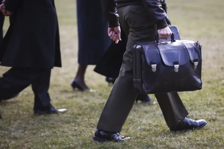 A military officer carries "The Football" onto Marine One as President Barack Obama departs the White House in Washington. The Nuclear Football is a black briefcase meant to be used by the President of the United States of America to authorize a nuclear attack while away from fixed command centers, such as the White House Situation Room. It functions as a mobile hub in the strategic defense system of the United States.