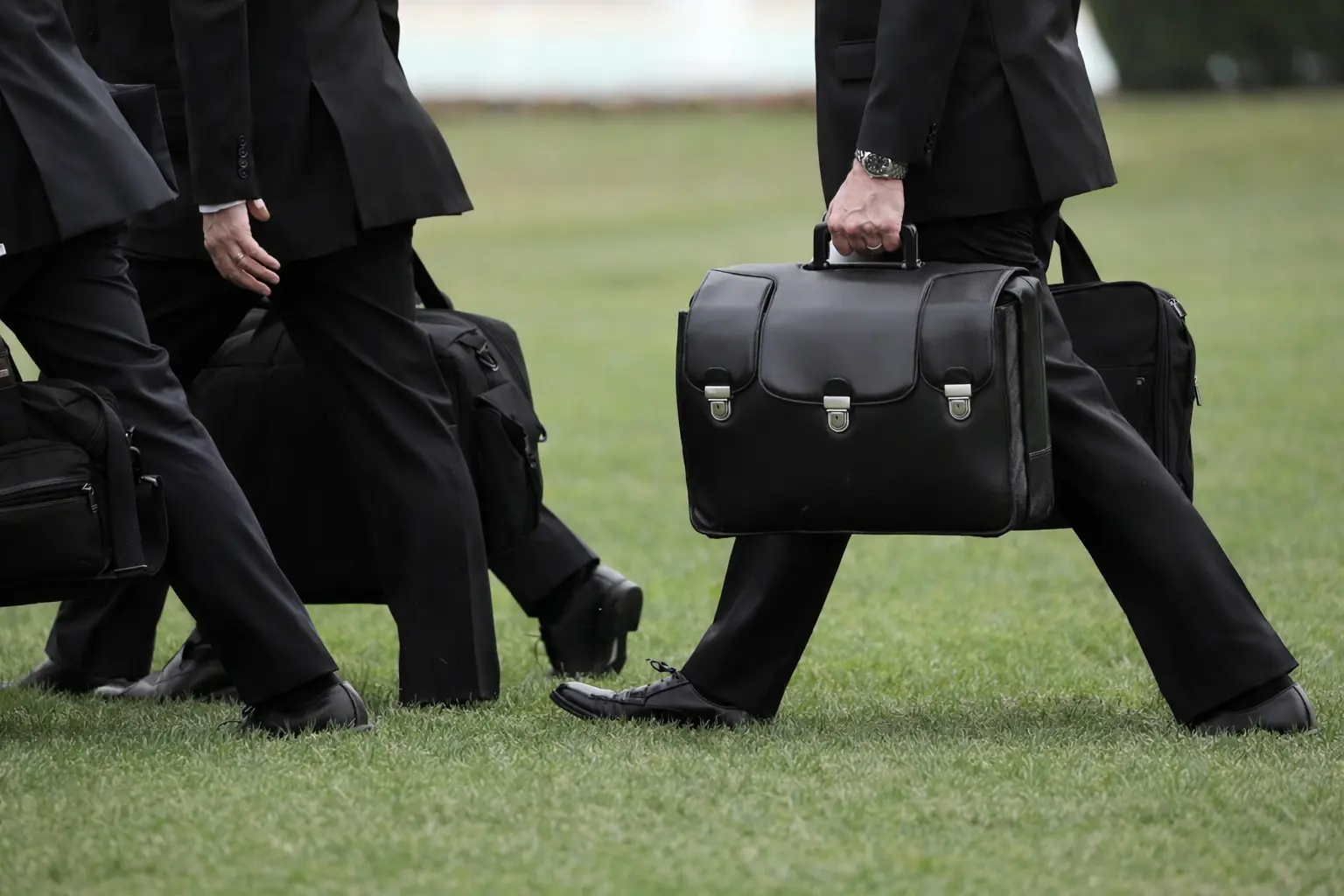A man walking with the Nuclear Football briefcase.