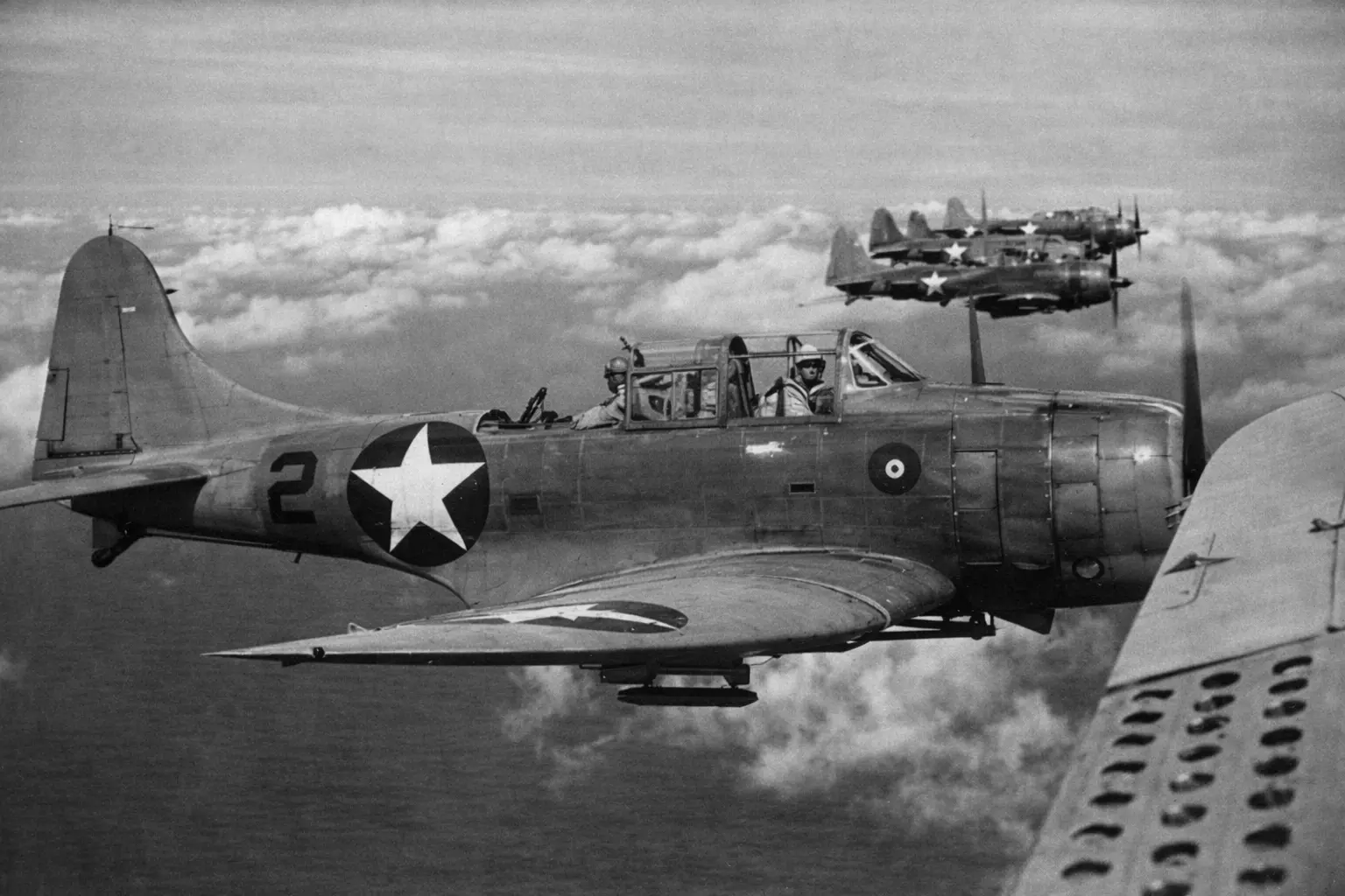 A few SBD Dauntless planes flying in the sky.