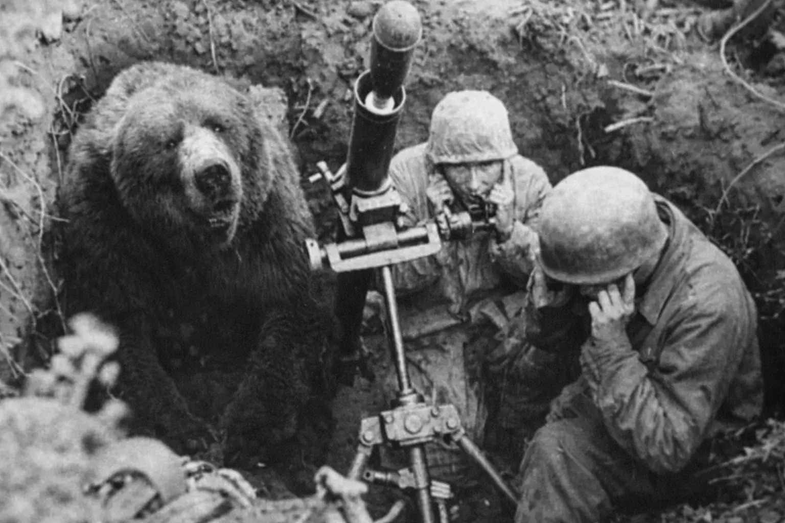 Wotjek with two soldiers in a trench as they fire mortars.