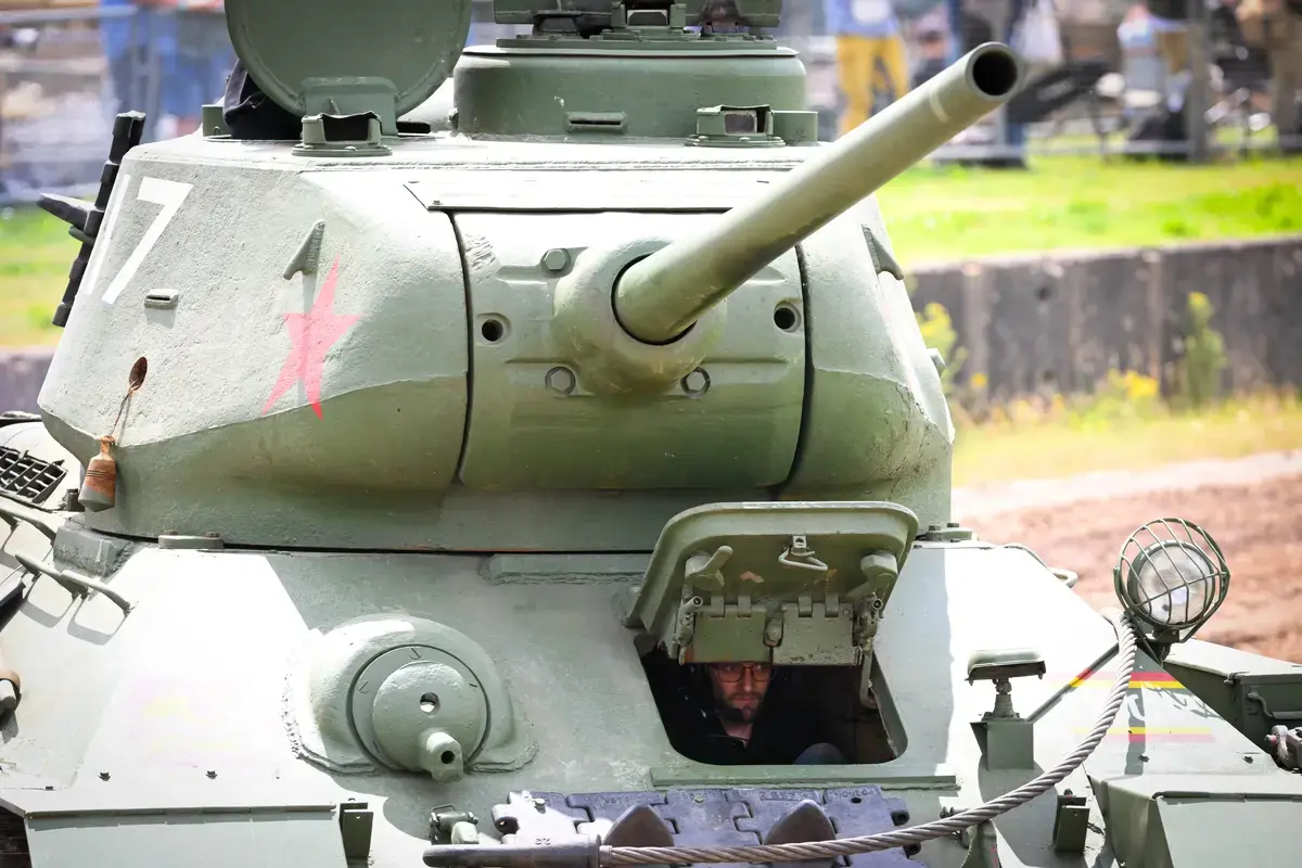A T-34 battle tank driver is seen during the display of tanks in the main arena at TANKFEST 2025 at The Tank Museum on June 27, 2025 in Bovington, Dorset. The Tank Museum holds the world's largest collection of tanks, covering the period from the First World War to the present day. TANKFEST is a three day event featuring the world's biggest live display of historic armor.