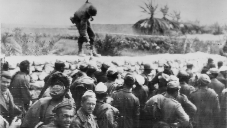 American soldiers hands out cigarettes to captured Italians of the Bersaglieri Division near El Guettar, Tunisia, March 1943