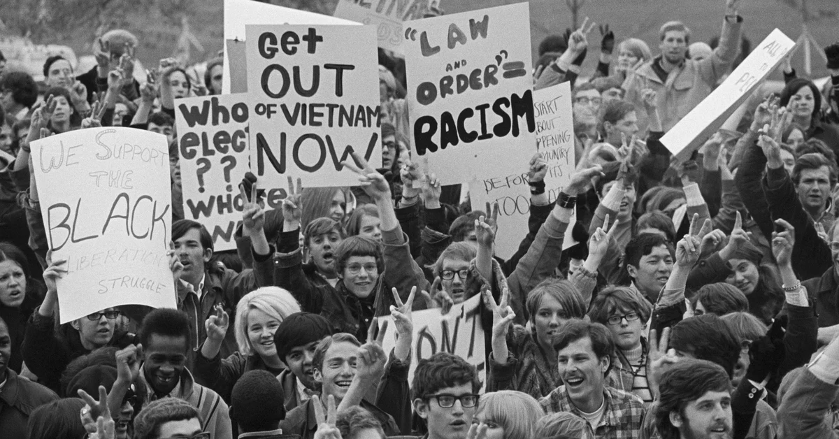 11/05/1968-Des Moines, IA- Participants in a Students for a Democratic Society-sponsored demonstration display signs protesting the general election as a "hoax" and calling for peace in Vietnam. The demonstration was staged on the steps of the Iowa capitol building after a three-mile march under police supervision.