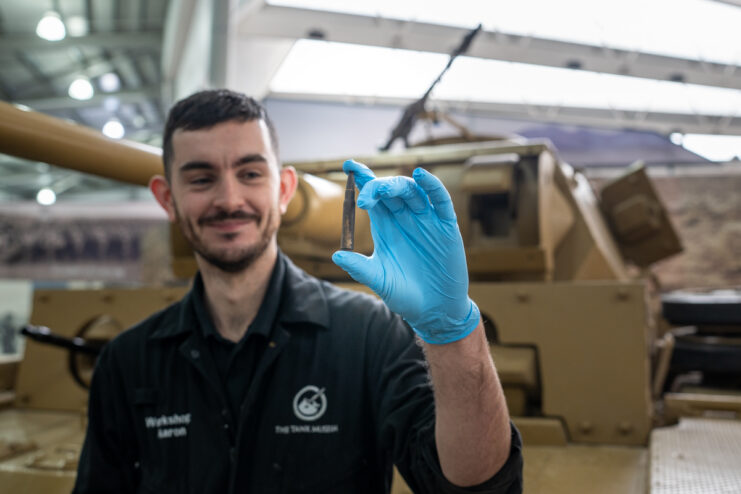 Workshop technician holding a Mauser round