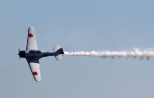 A Zero flying through a blue sky.