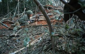 Picture shows the 173 Airborne at hill 875. US soldier is shown lying down on the ground holding a gun.