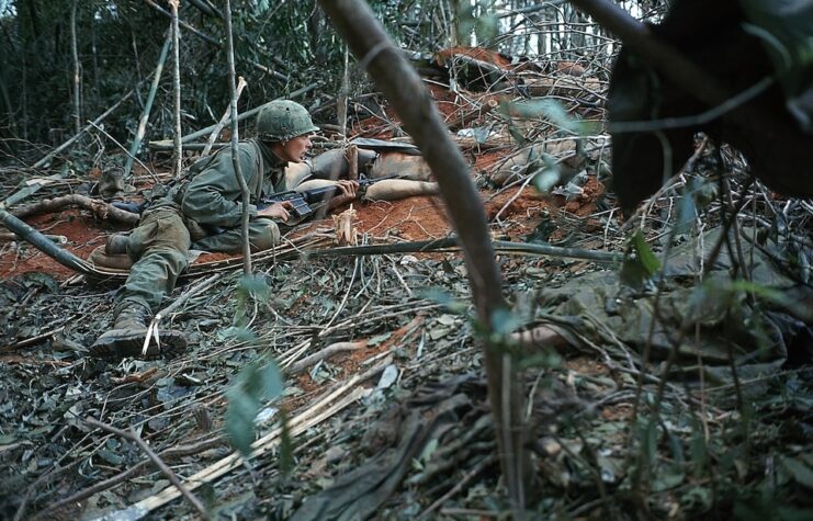 Picture shows the 173 Airborne at hill 875. US soldier is shown lying down on the ground holding a gun.