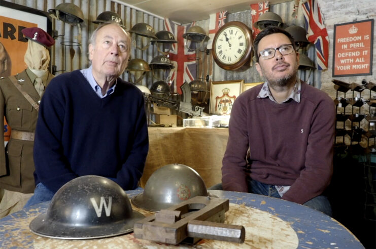 David and Stephen Nuwar sitting at a table topped with military memorabilia